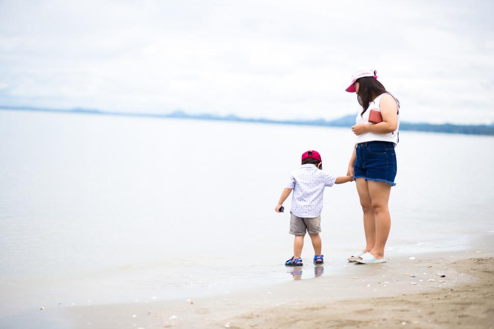Free Image of Asian boy and mother walking the tropical beach 