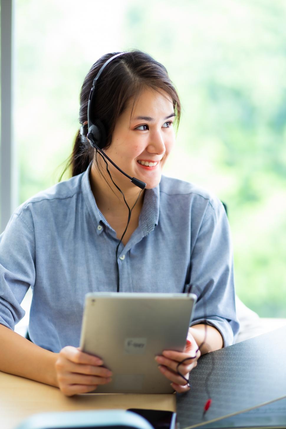 Free Image of Asian woman in headset smiling 