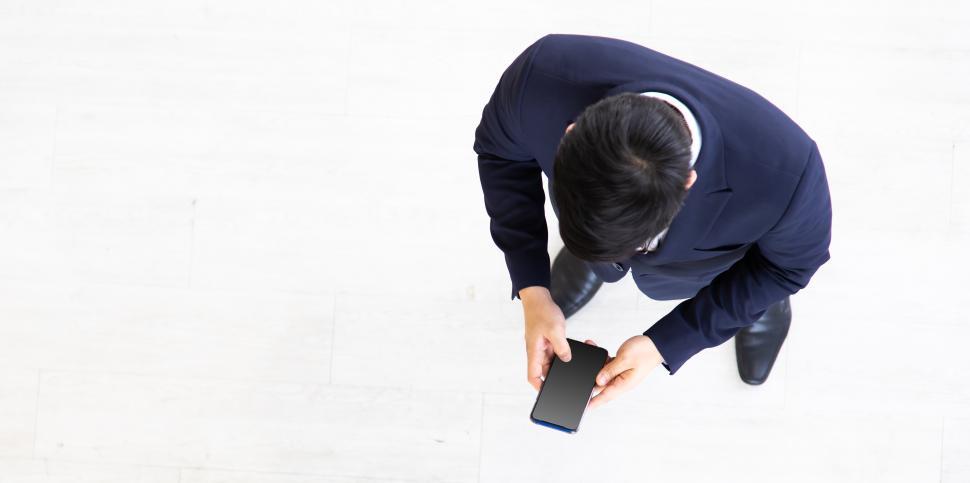Free Image of Asian business man reading news on mobile phone 