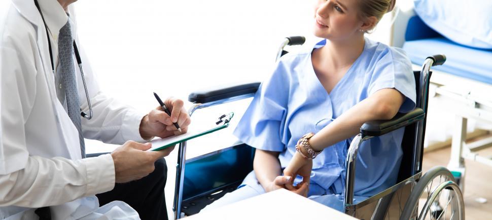 Free Image of Patient in wheelchair speaking to doctor 