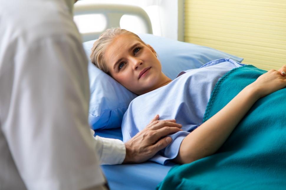 Free Image of Doctor reassuring her female patient on bed at hospital room 