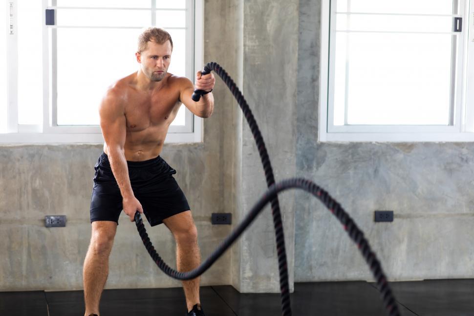 Free Image of Fitness man training with battle ropes in cross fit gym 