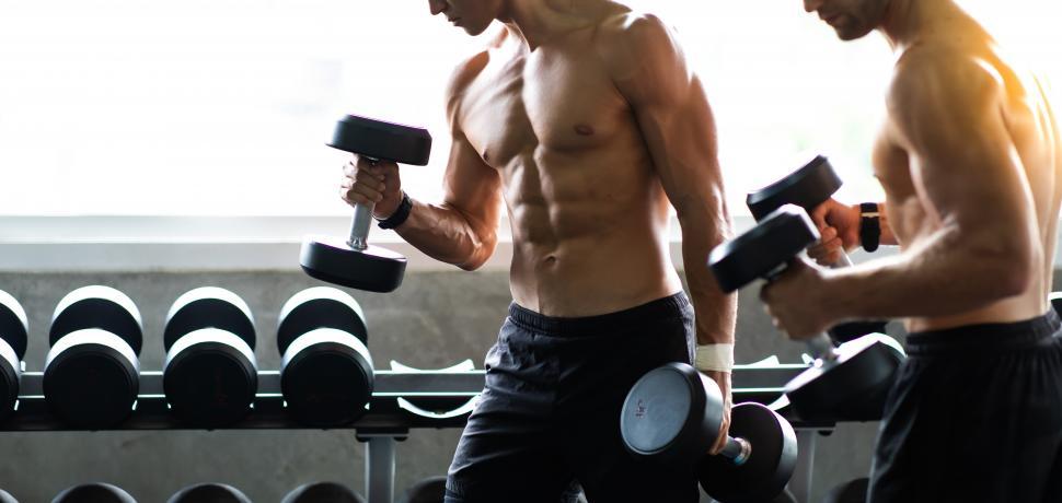 Free Image of Young bodybuilder exercising lifting with dumbbells 