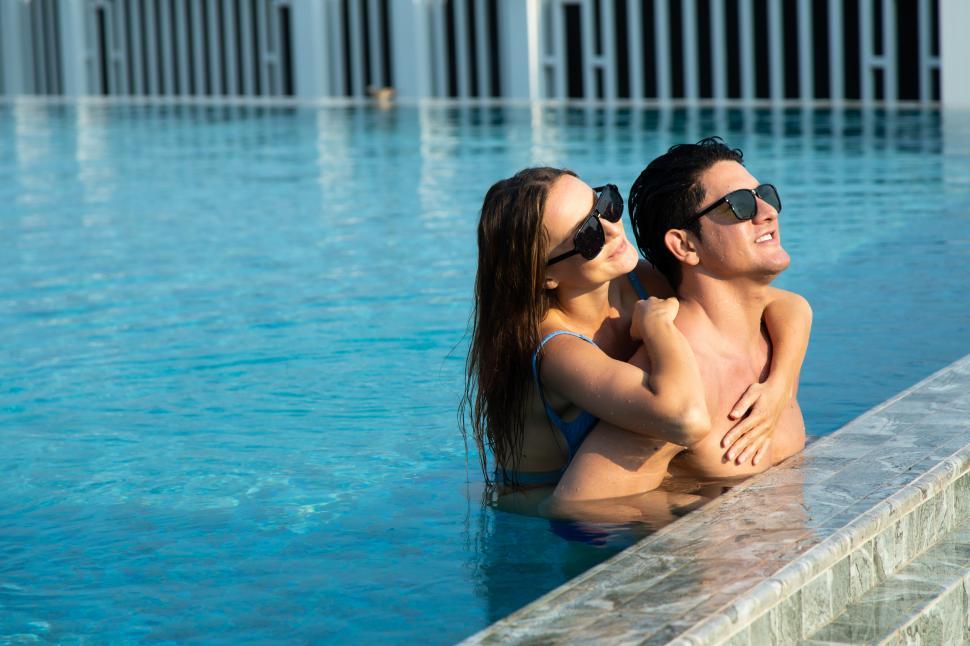 Free Image of happy young couple by the pool 