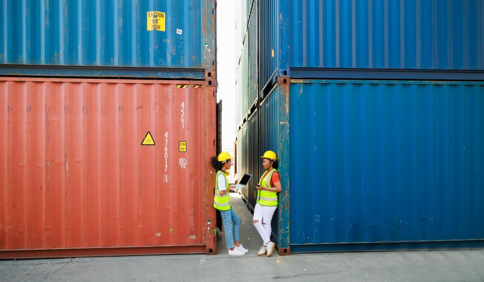 Free Image of Two Black female dock workers relax and talk 