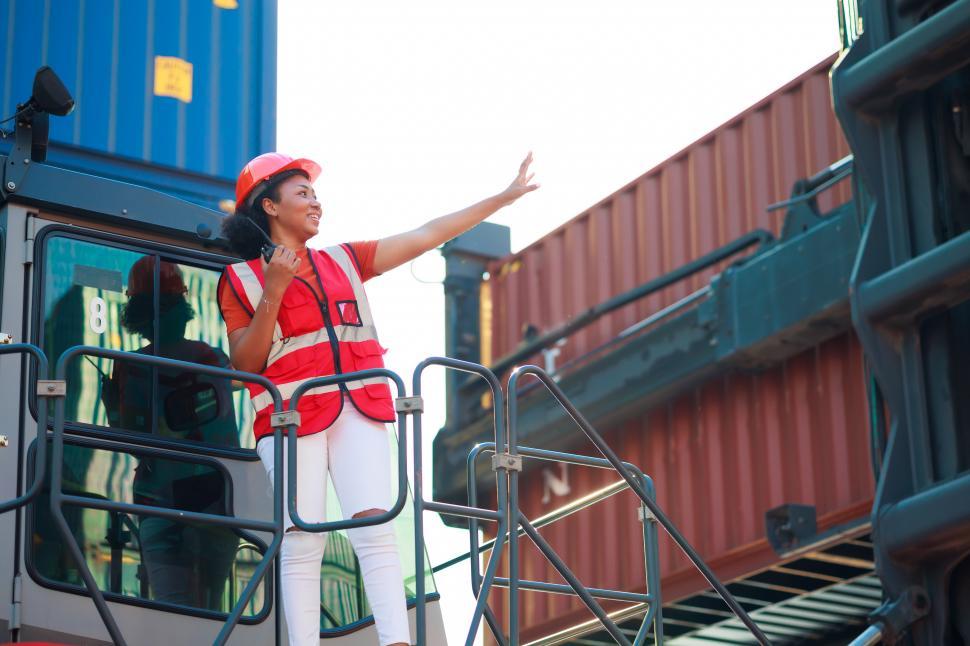 Free Image of Dock worker controls loading containers 