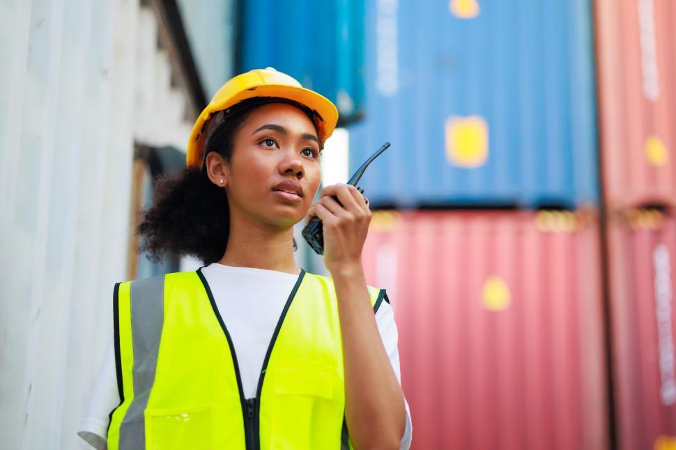 Free Image of Black female dock worker controls loading of containers 