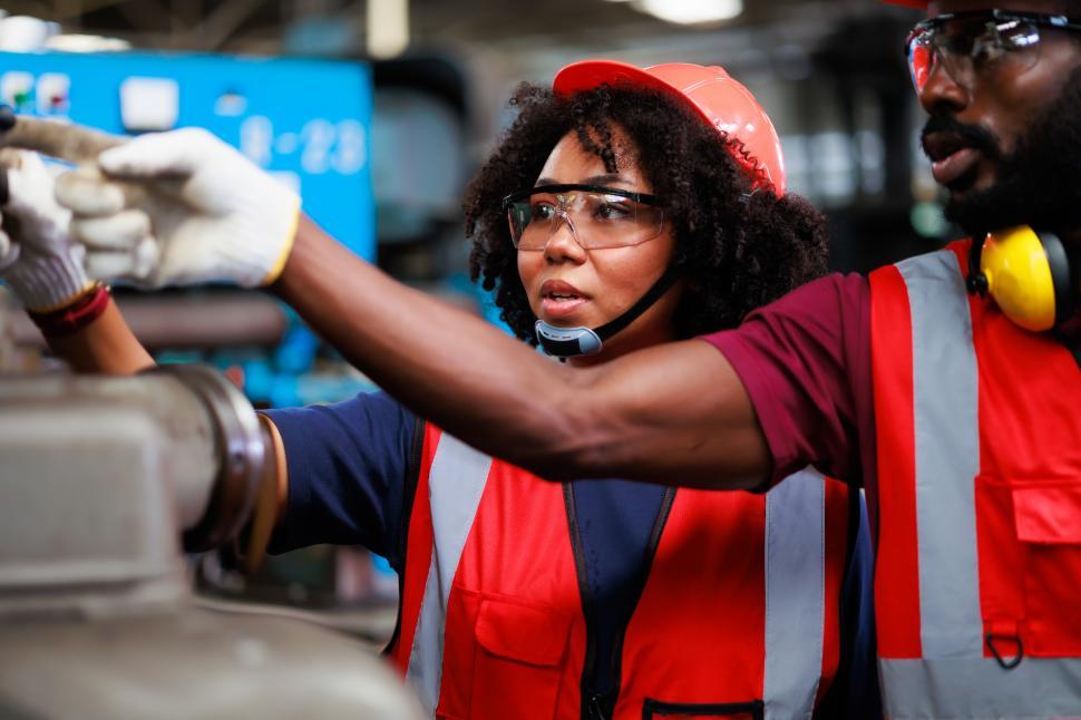 Free Image of Black Woman wearing safety goggles controlling machinery 