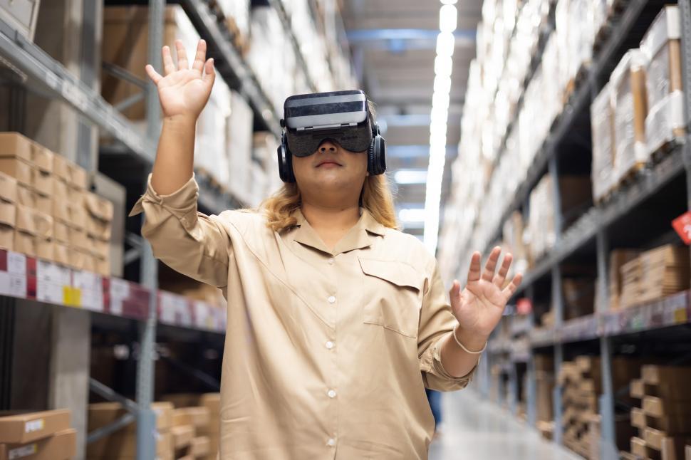 Free Image of Woman inspecting box of products using virtual reality headset 