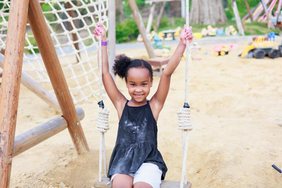 Free Image of Young girl playing on a playground swing 