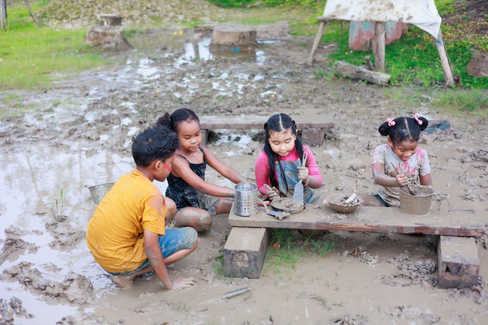 Free Image of Young children playing in puddle mud together 