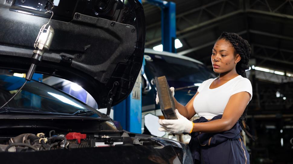 Free Image of Young female car mechanic changing car air filter 
