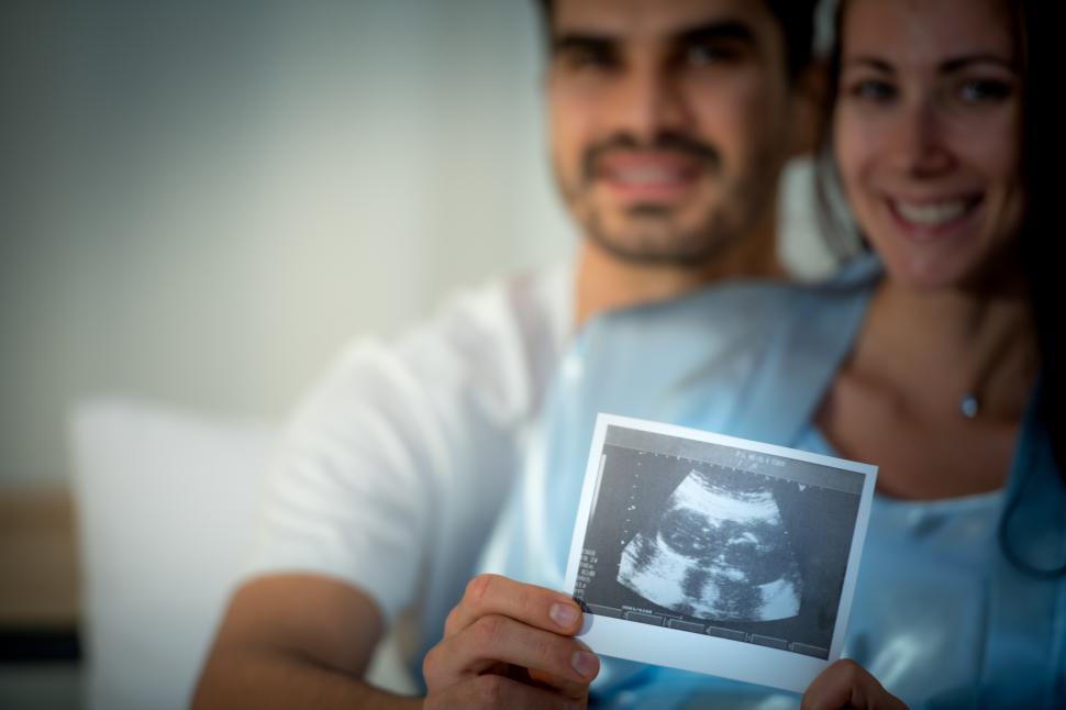 Free Image of The happiness of a pregnant woman and her husband with sonogram  