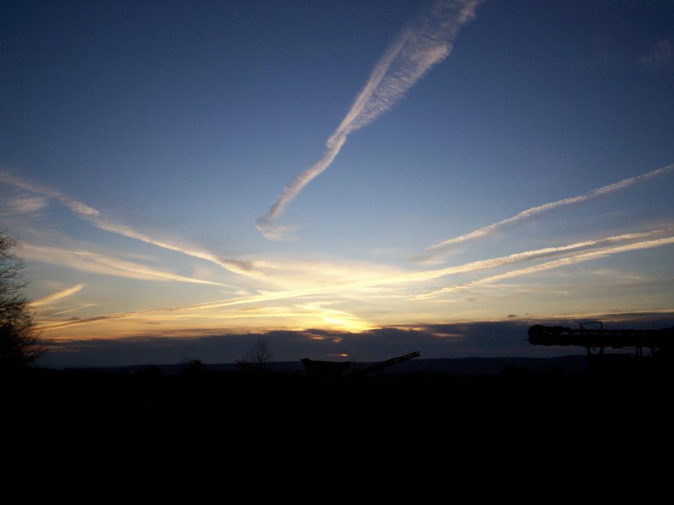 Free Image of Sunset With Contrails in the Sky 