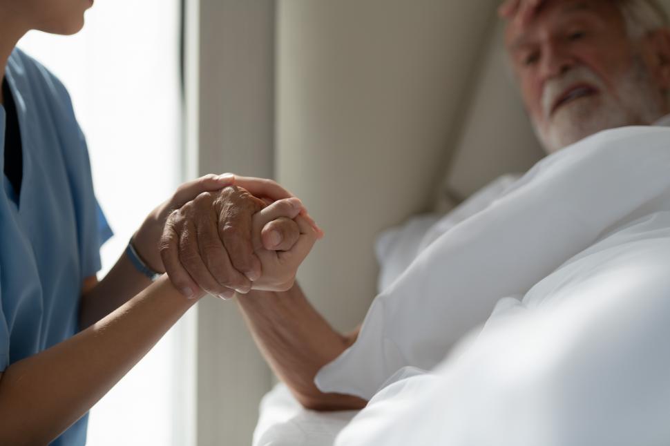 Free Image of Doctors hold hands and give encouragement to elderly patient 