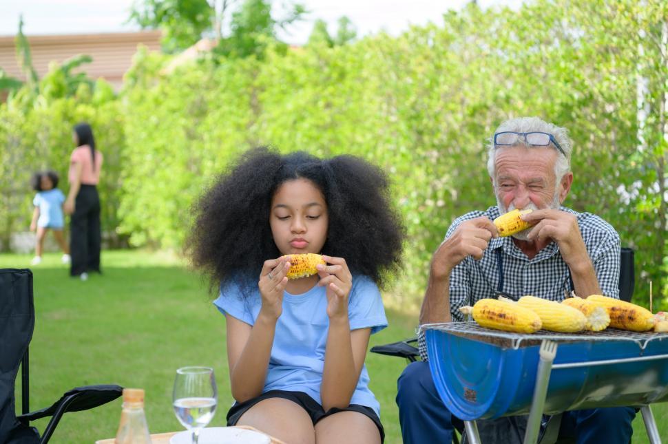 Free Image of Family holiday activities - eating grilled corn 