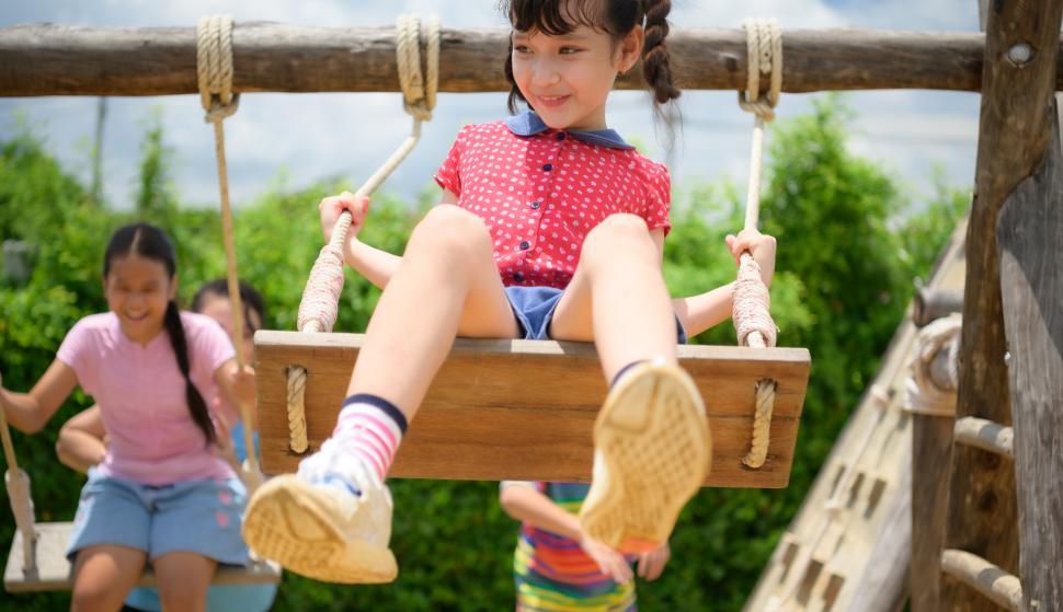 Free Image of Childrens having fun swinging on a swing on a clear day 
