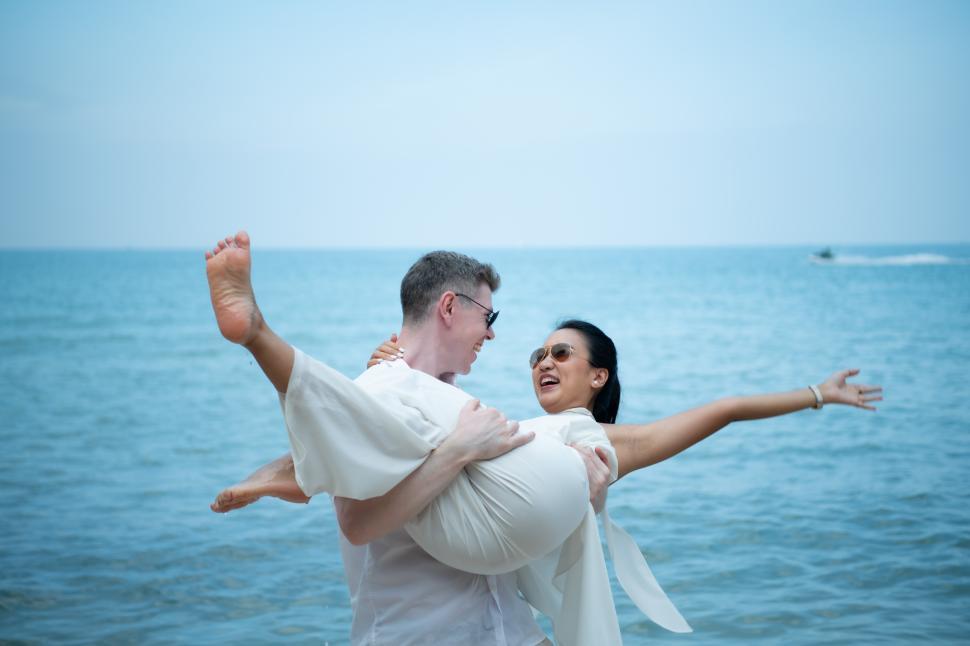 Free Image of Interracial couple with the joy of traveling to the beautiful beach 
