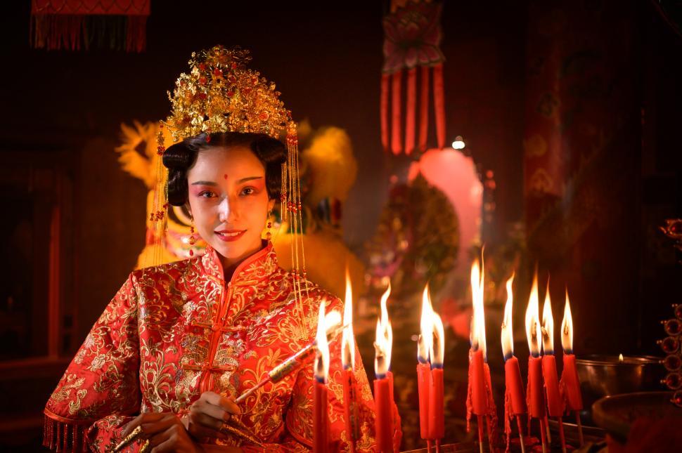 Free Image of Chinese woman makes wishes, prays, and lights candles during Chinese New Year 