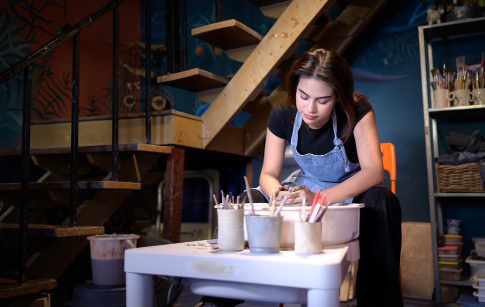 Free Image of Woman working in pottery studio throwing pots 