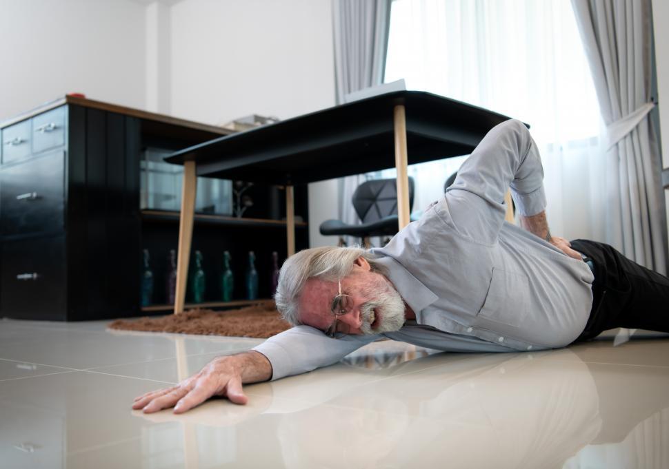 Free Image of Elderly man falls down in the living room inside his home 