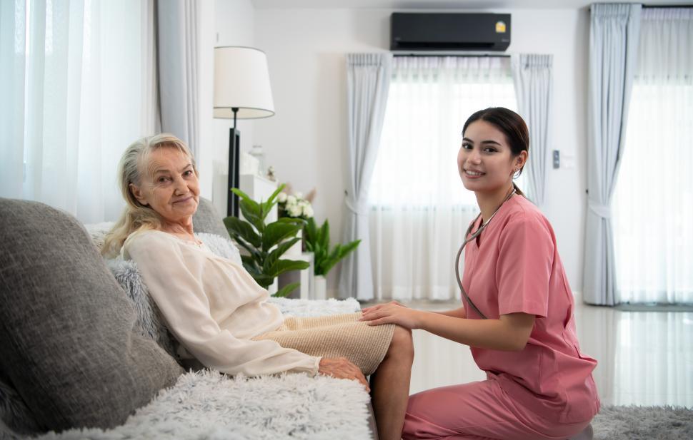 Free Image of Caregiver for an elderly woman at in home visit, looking at the camera 