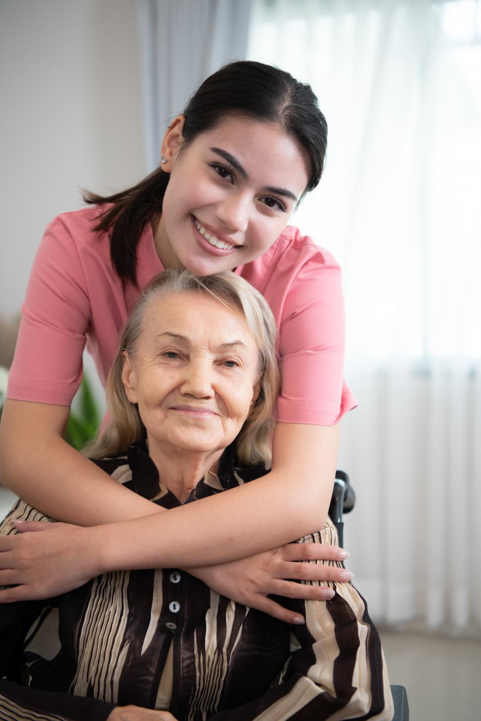 Free Image of Caregiver poses with the elderly woman she takes care of every day 