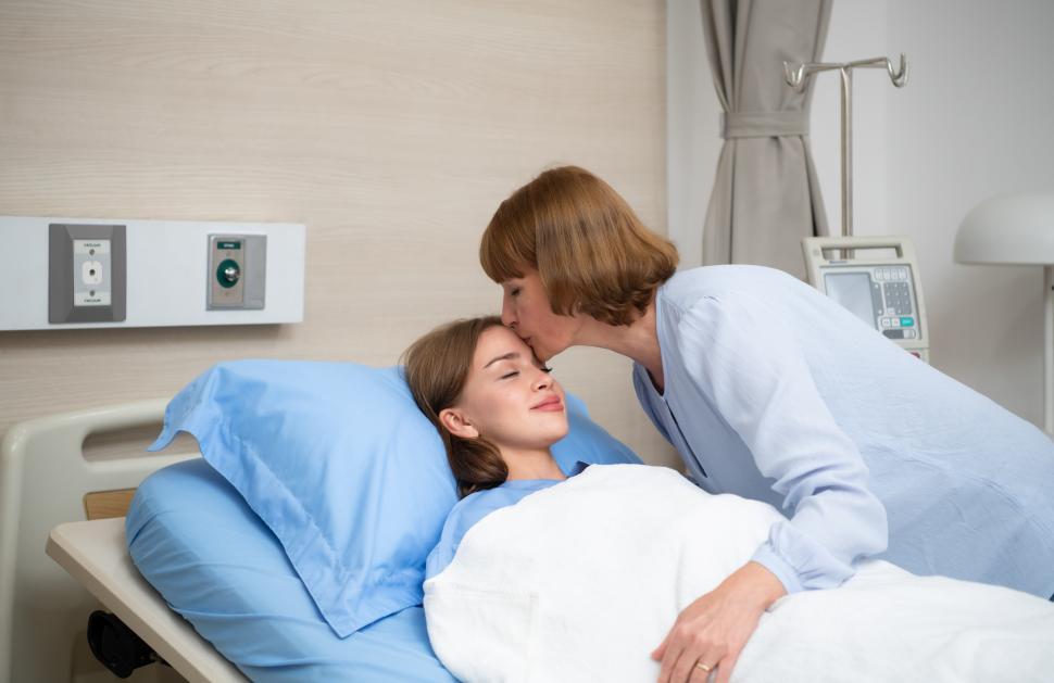 Free Image of A mother kisses her child who is hospitalized 