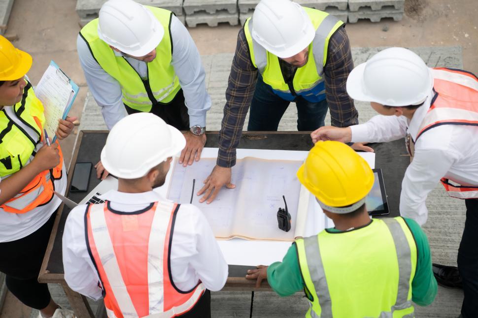 Free Image of Construction engineers, architects, and foremen form a group to look at plans 