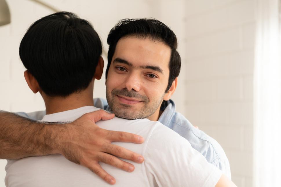 Free Image of Two men embracing, one looking at the camera 
