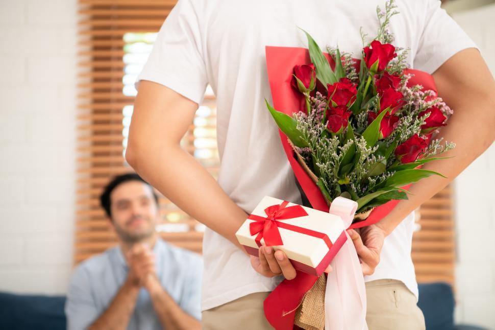 Free Image of Man presenting flowers and a gift to his partner as a surprise present 
