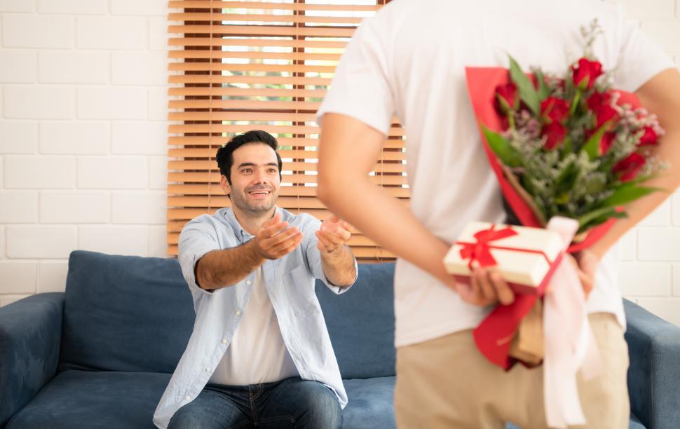 Free Image of Young man surprises his boyfriend with roses and gifts 