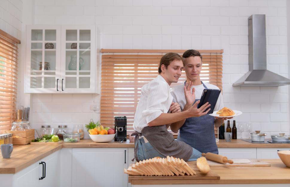 Free Image of Young couple examine online recipes for evening meal 
