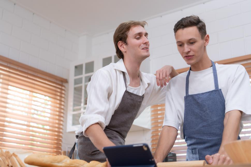 Free Image of Two young men cooking together in a modern kitchen 