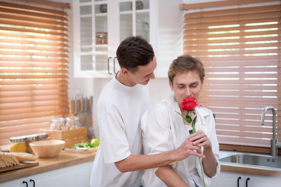 Free Image of A young LGBT couple celebrates a day of love with a red rose 