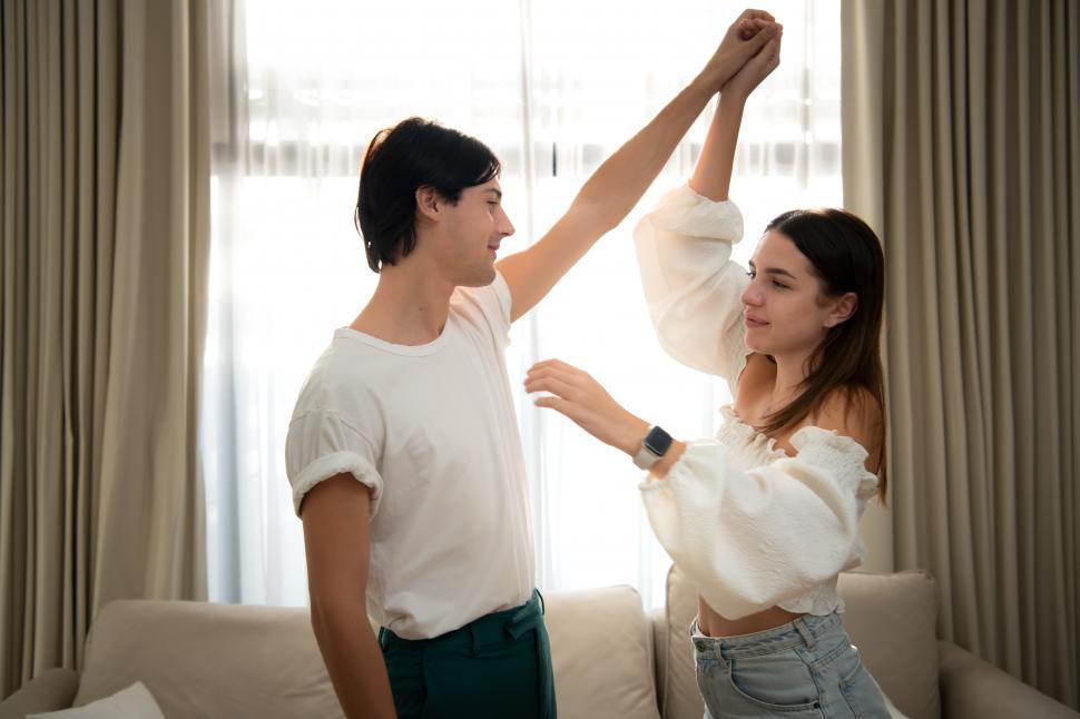 Free Image of Young couple dance in the living room of the house in the morning 