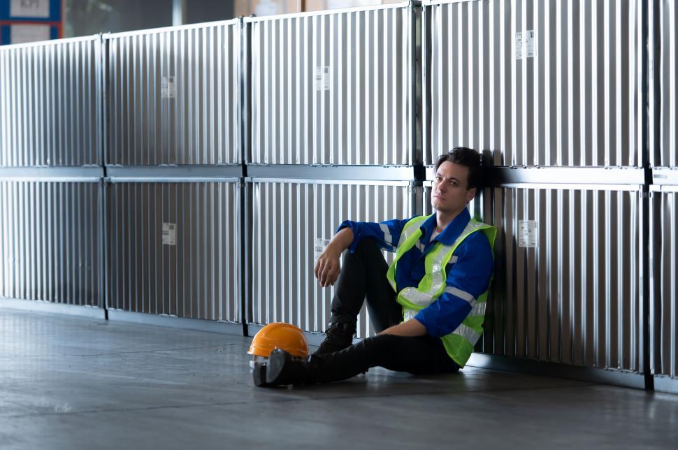 Free Image of Worker in an warehouse is exhausted at the end of a long day 