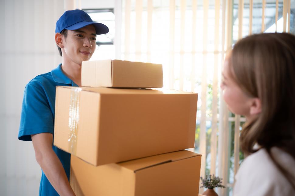 Free Image of The delivery man brings many boxes to the customer 