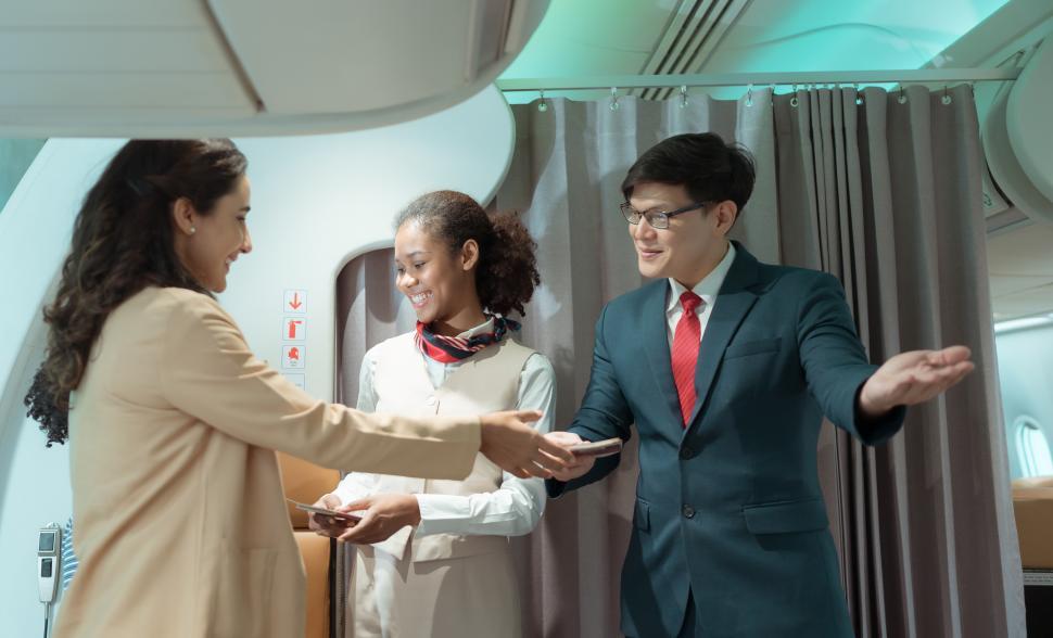 Free Image of Flight attendant greet passengers as they enter the aircraft 