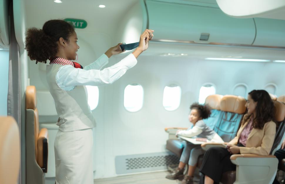 Free Image of Flight attendants show how to use seatbelts before flight 