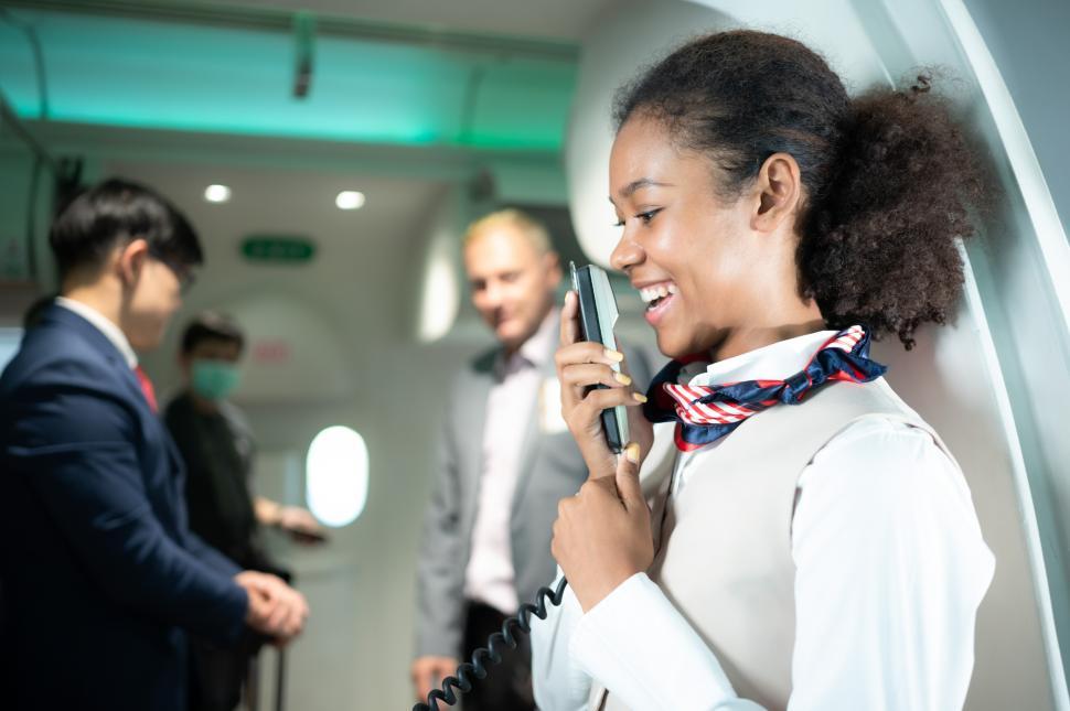 Free Image of Flight attendant speaking through a loudspeaker to welcome passengers onboard 