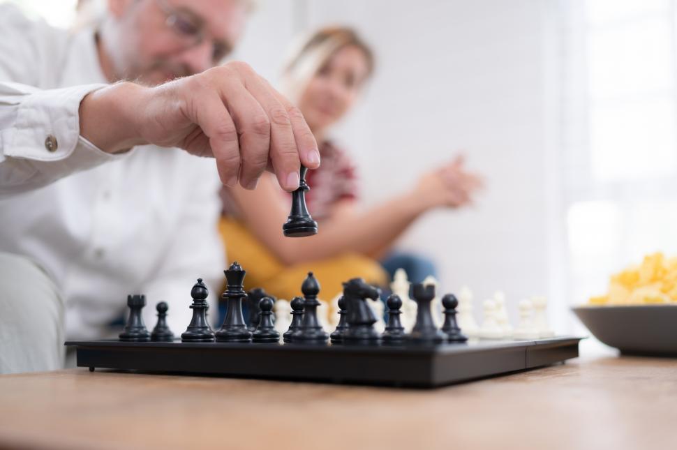 Free Image of An elderly couple playing chess together in the living room 