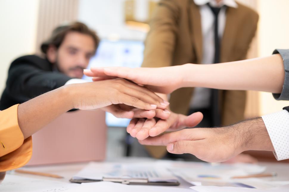 Free Image of Businesspeople motivate each other by stacking hands. 