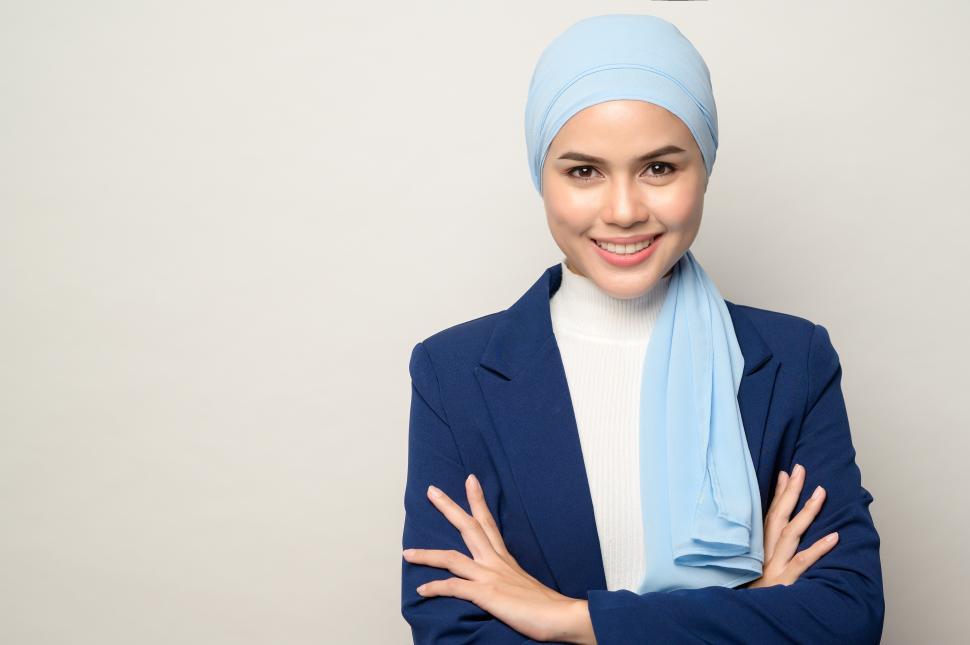 Free Image of close up of young beautiful muslim businesswoman with hijab, arms crossed 