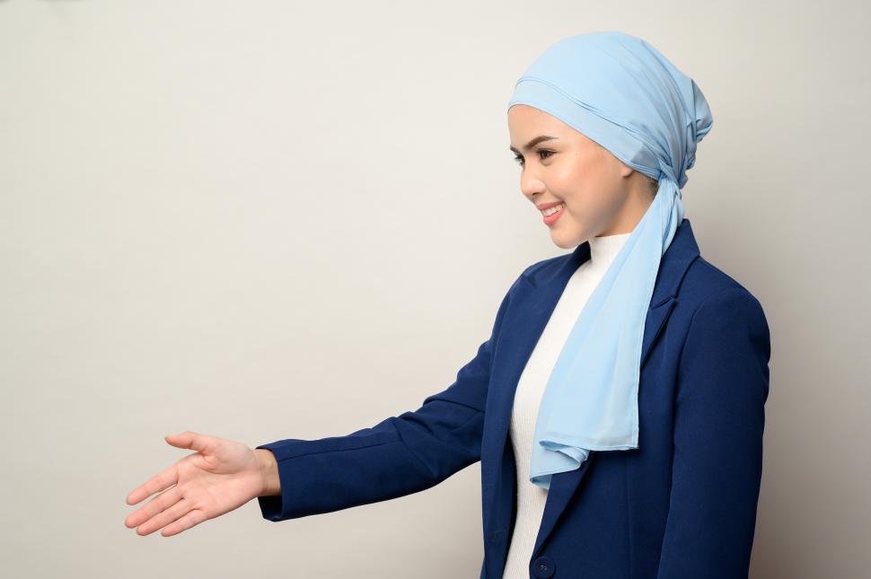 Free Image of Young muslim businesswoman with hijab isolated, offering handshake 