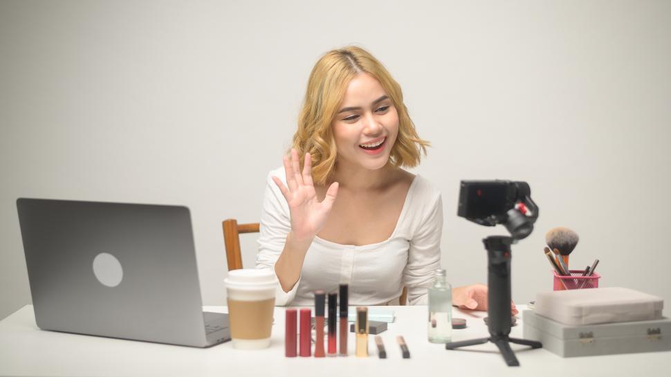 Free Image of Young blonde woman entrepreneur working with laptop presents cosmetics 