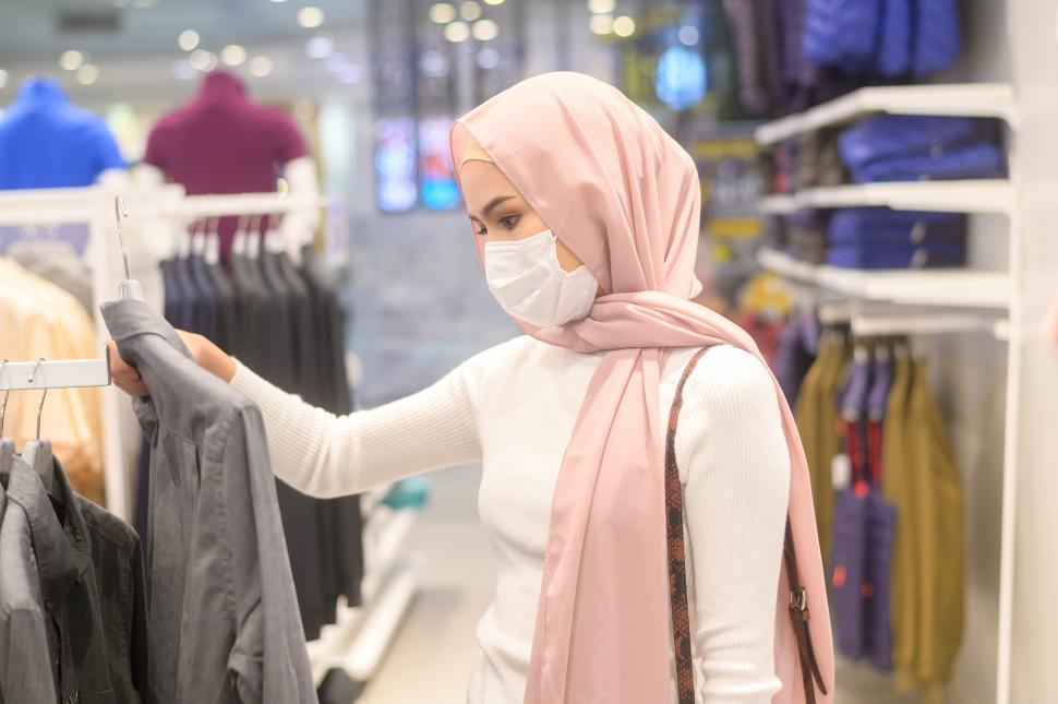 Free Image of Young muslim woman browsing clothes at a store in a shopping mall 