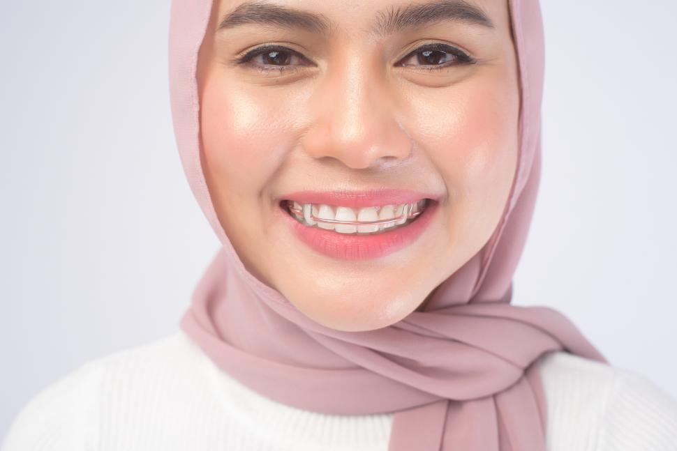 Free Image of Young muslim woman wearing colorful orthodontic retainer for teeth 