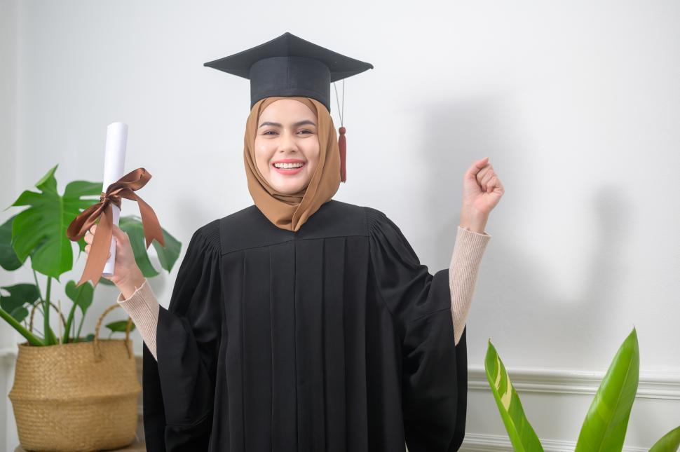 Free Image of Young muslim woman graduating and holding a diploma 