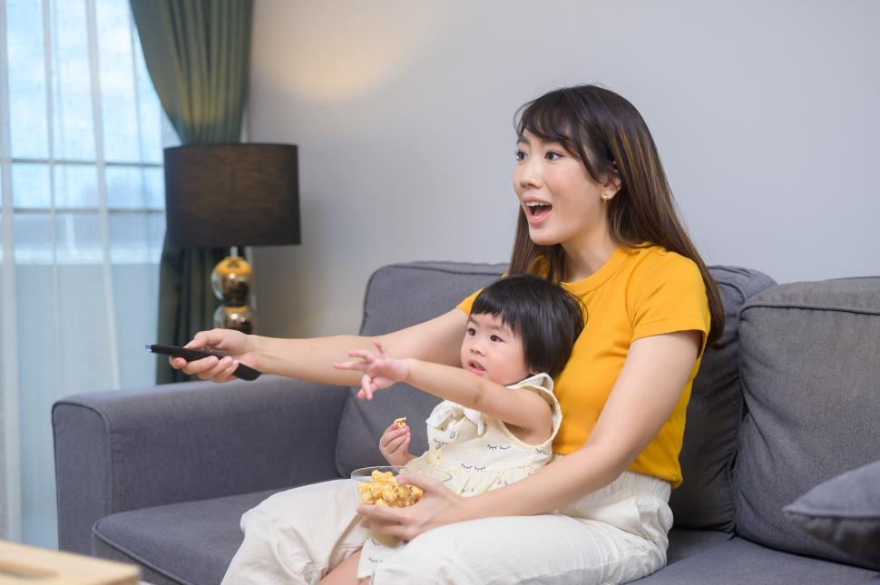 Free Image of Happy mom and daughter watching movie and relaxing at home 